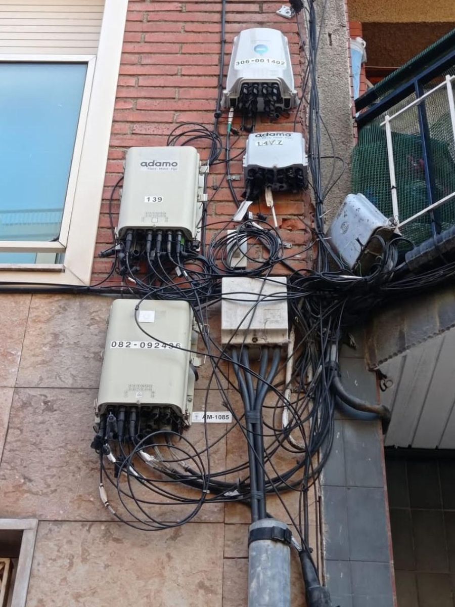 Façana amb cablejat de telecomunicacions abandonat